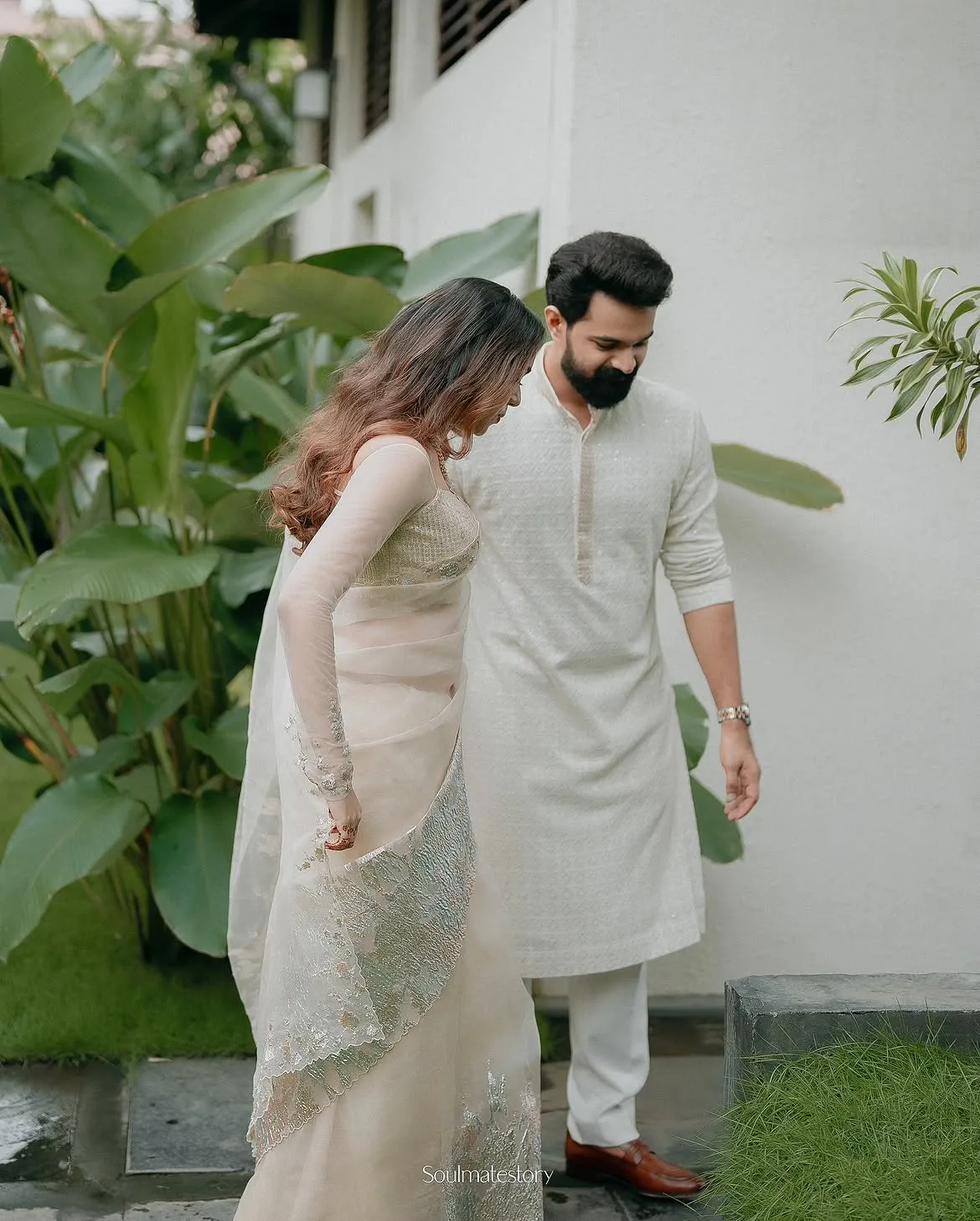 A couple walking together through a lush tropical garden